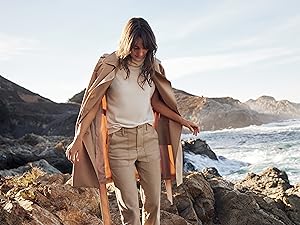 woman walking on the rocks by the water 