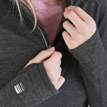 woman zipping up her merino wool half zip hoodie with reflective zipper and thumbholes